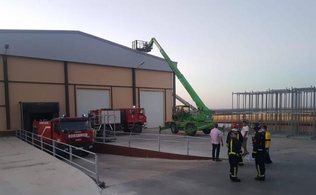 Los bomberos y personal del Ayuntamiento intervienen en la nave afectada en Carbonero el Mayor. 