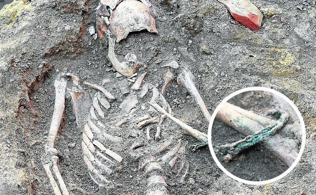 Uno de los esqueletos hallados en la excavación, y en detalle, la pulsera robada. 