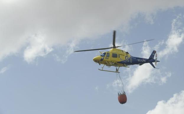 Un helicóptero trabaja para controlar el incendio. 