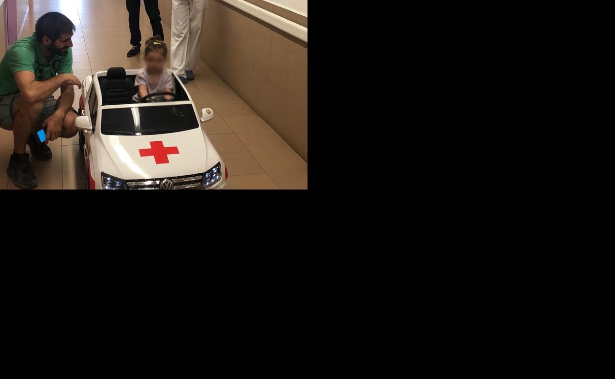 Una niña conduce el coche eléctrico del hospital de los Santos Reyes. 