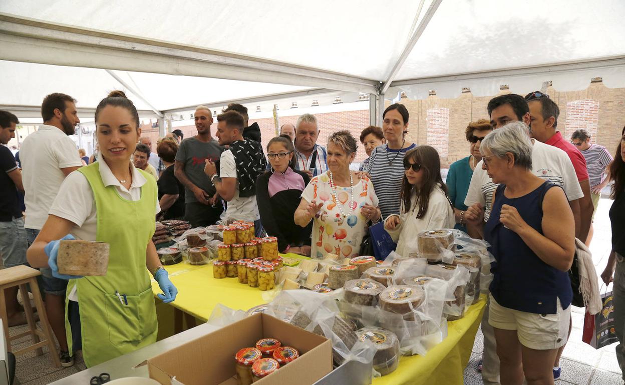 Varias personas prueban el queso de San Martín, en la Feria de Queso de Frómista. 