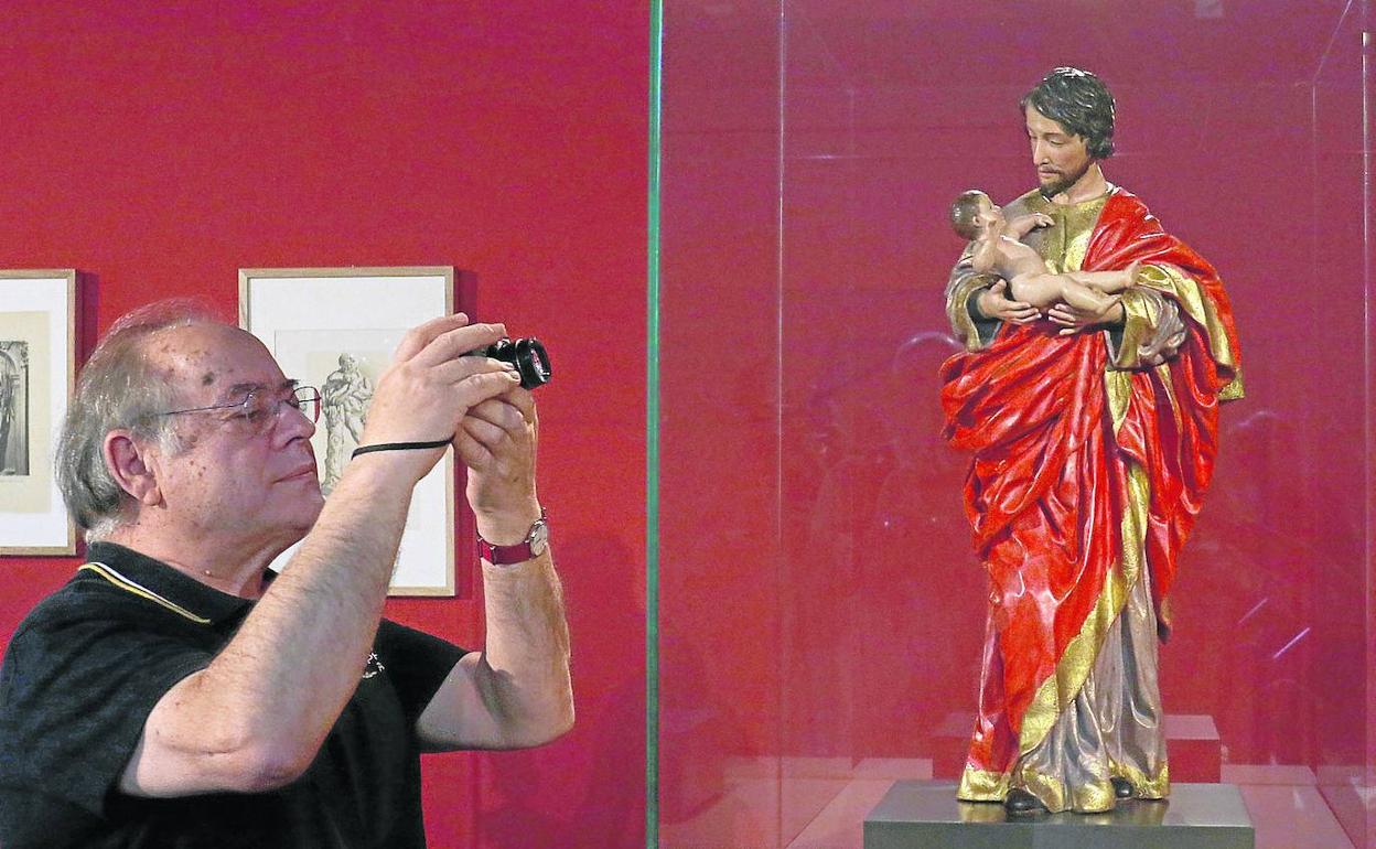 Un visitante fotografía la escultura de San José. 