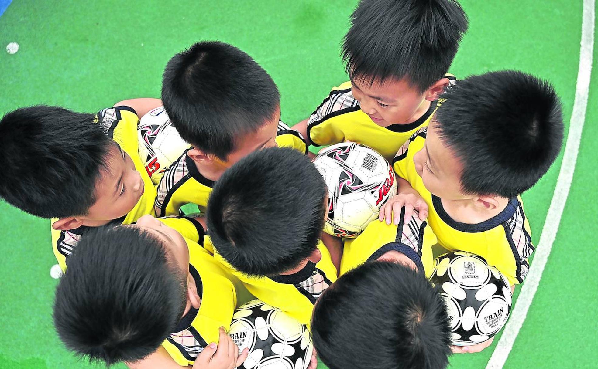 Un grupo de siete niños se entrenanen una de las escuelas de fútbol