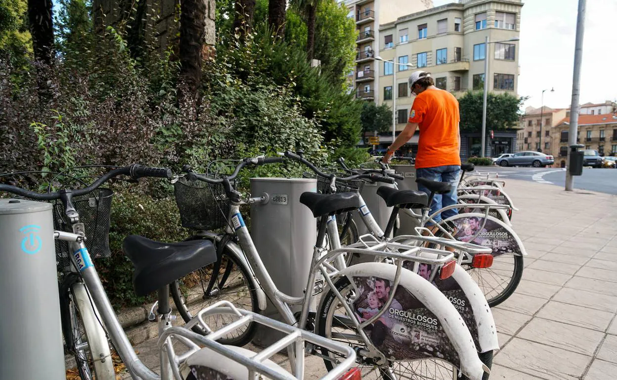 Un usuario del servicio recoge una bici en el punto de préstamo de La Alamedilla.