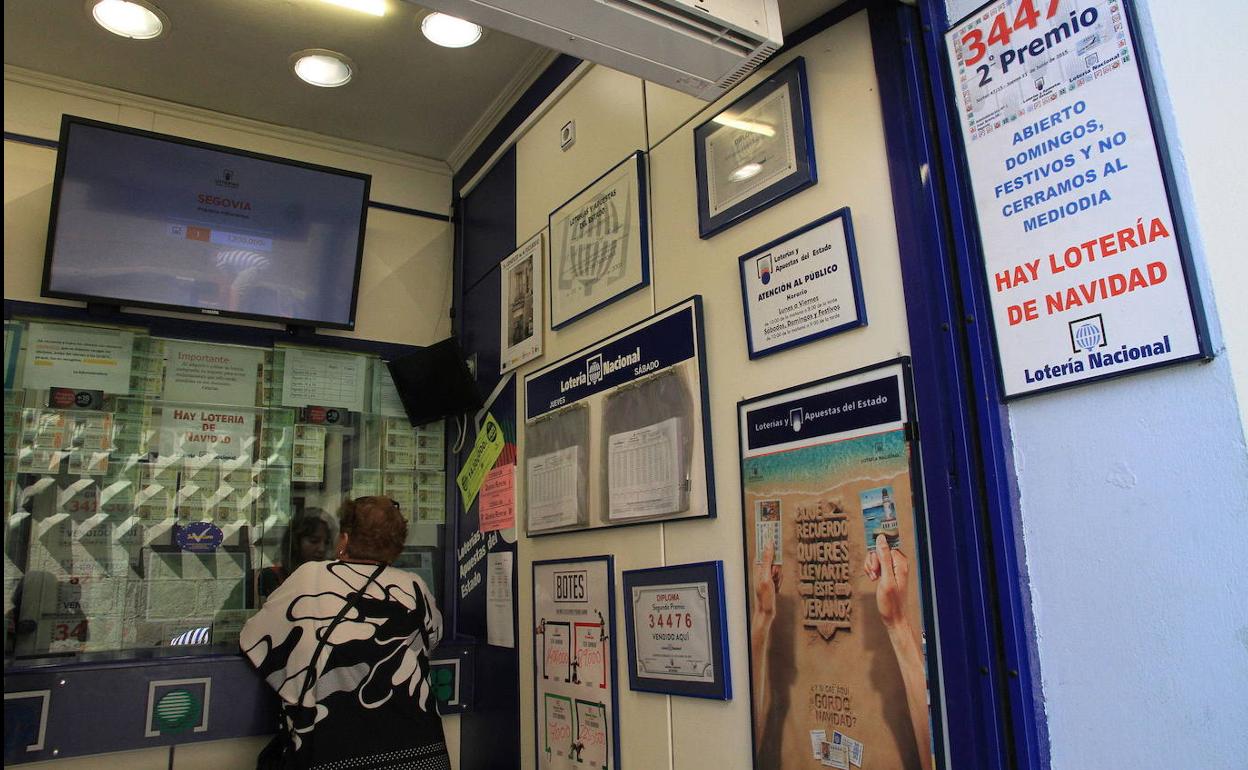 Una mujer compra loteria en la ventanilla de la administración de la Casa de los Picos de Segovia. 