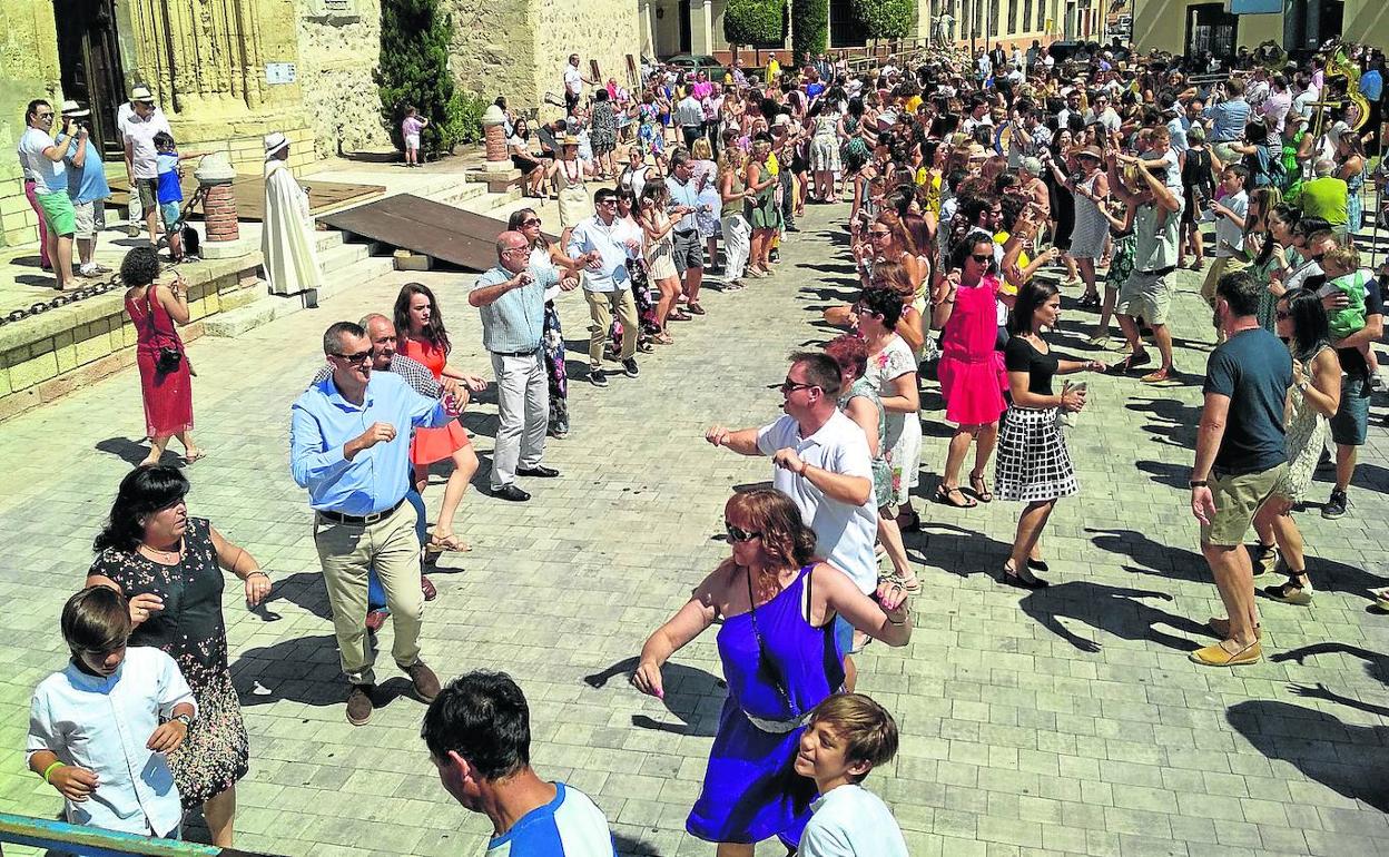 Los vecinos de Aguilafuente disfrutan con los pasos de baile en un momento de la procesión. 