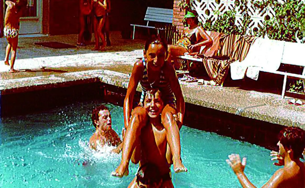Mi hermano Ángel nos sujeta a mí y a mi prima Pilar en la piscina de los apartamentos Marola.