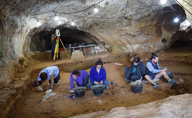 Arriba, aspecto general del trabajo en la cueva.