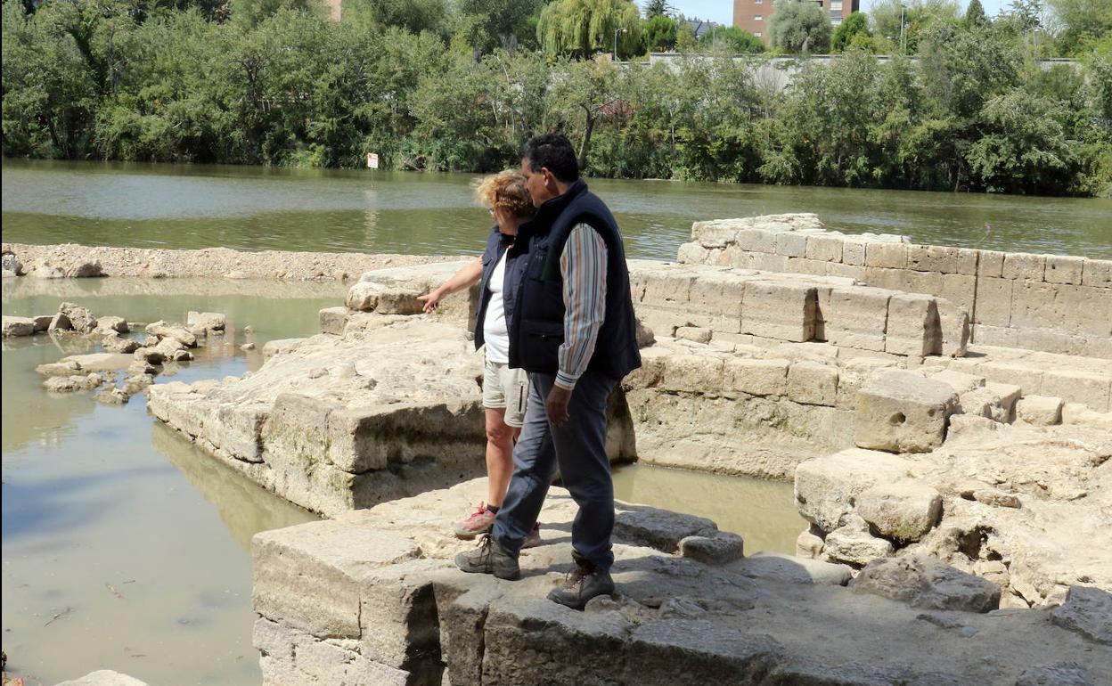 Ana Martínez y Arturo Balado, arqueólogos del proyecto de recuperación, sobre las aceñas del río. 