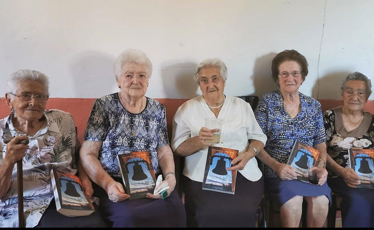 Mujeres del pueblo con el libro en su honor. 