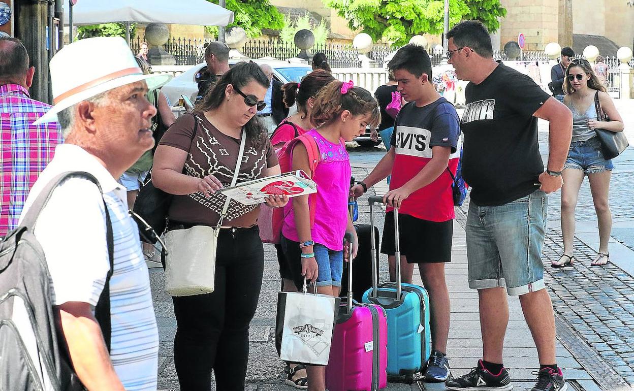 Un grupo de turistas camina con sus maletas por la Plaza Mayor de Segovia. 