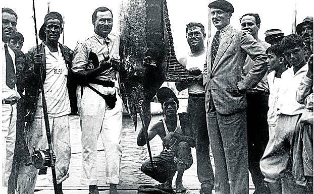 Sidney Franklin, con traje, corbata y boina, y su amigo Ernest Hemingway, flanquean un imponente pez espada en el puerto de La Habana, el 1 de julio de 1934.
