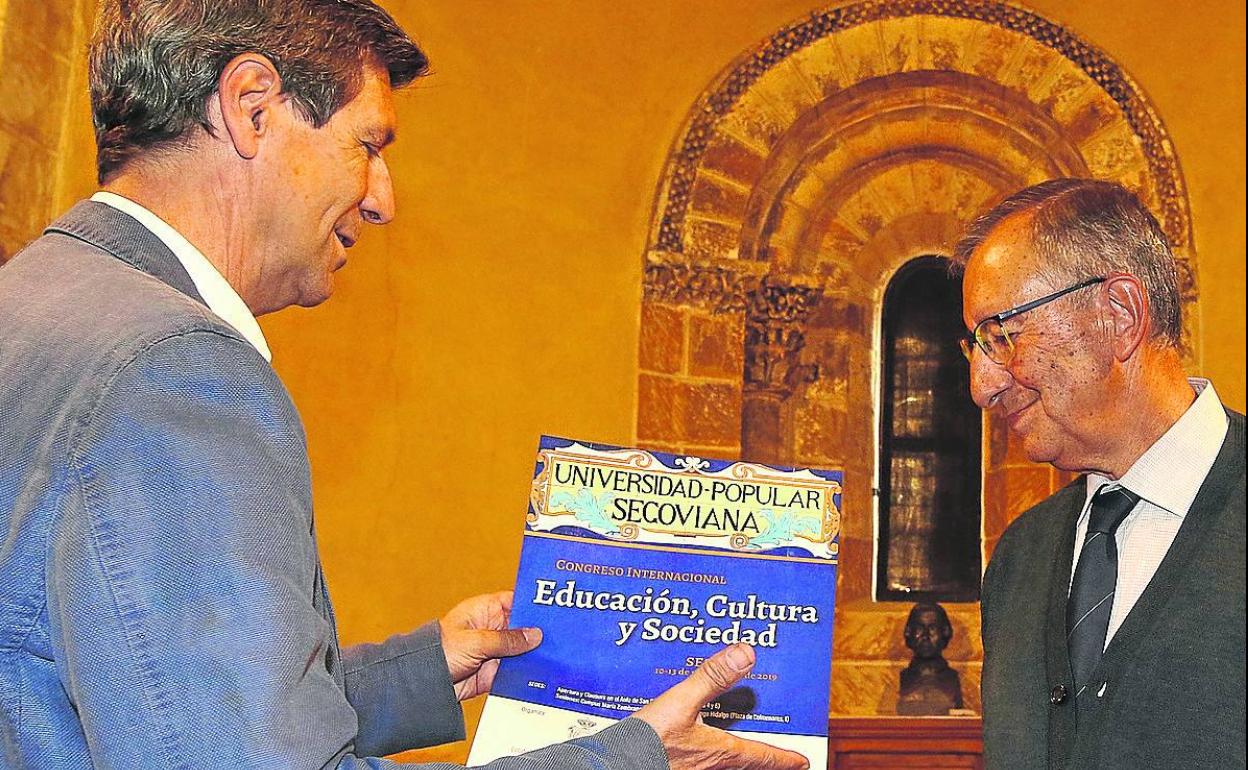Rafael Cantalejo, director de San Quirce, muestra el cartel del congreso a José Luis Mora. 