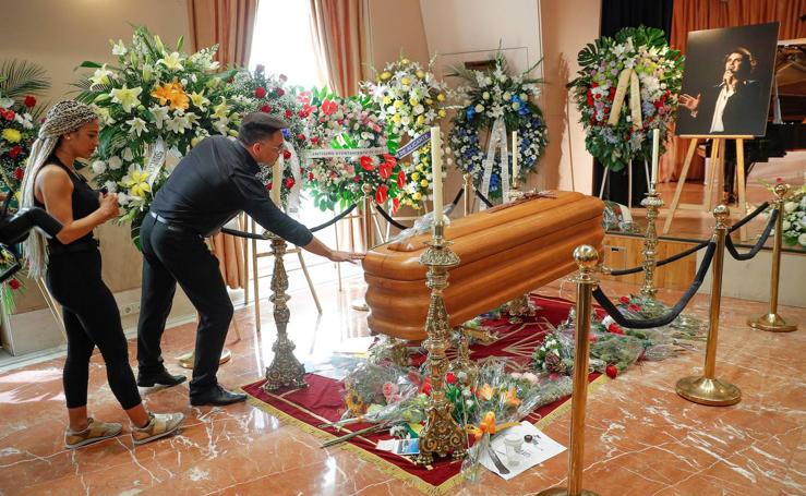 Dos personas muestran sus respetos en la capilla ardiente del cantante Camilo Sesto.