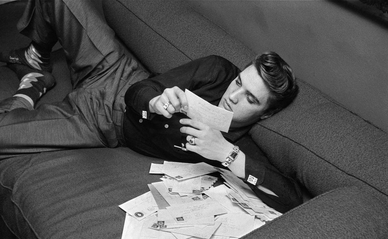 Elvis Presley, músico estadounidense, retratado por el fotógrafo Alfred Wertheimer, mientras leía cartas de sus fans.