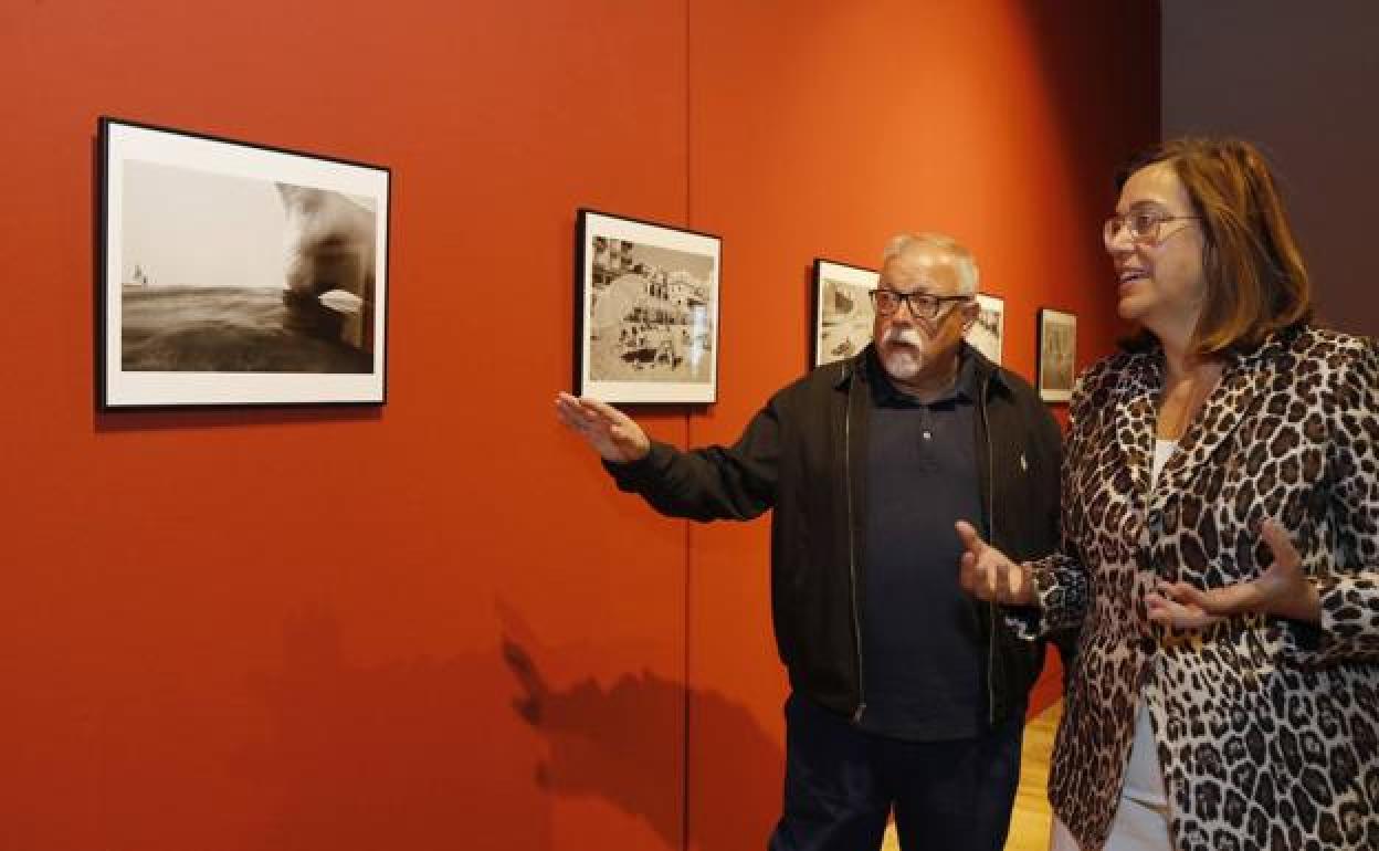 El fotógrafo Juan Manuel Díaz Burgos, explica a Ángeles Armisén, algunas de las fotografías de la exposición. 