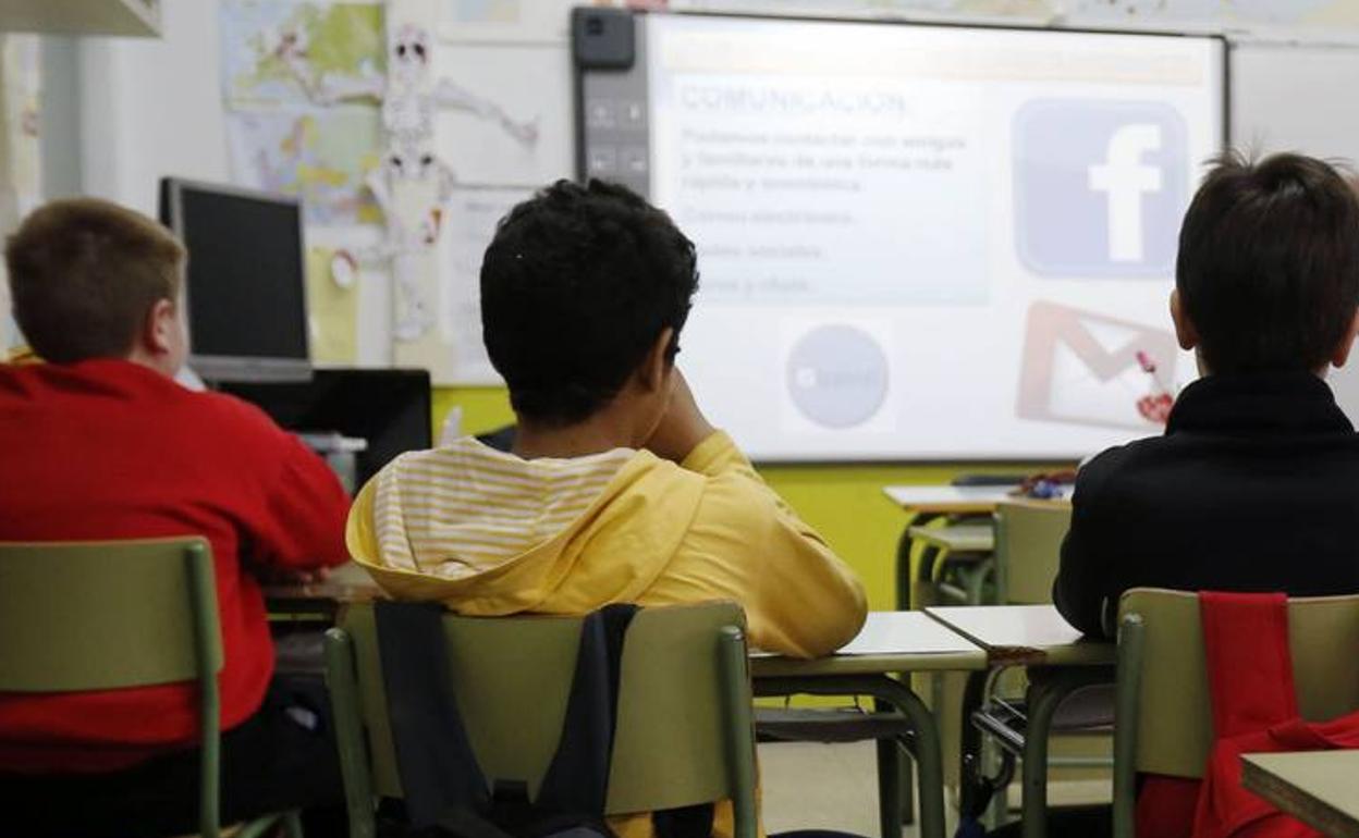 Tres escolares en una charla preventiva sobre el ciberacoso en un escuela.