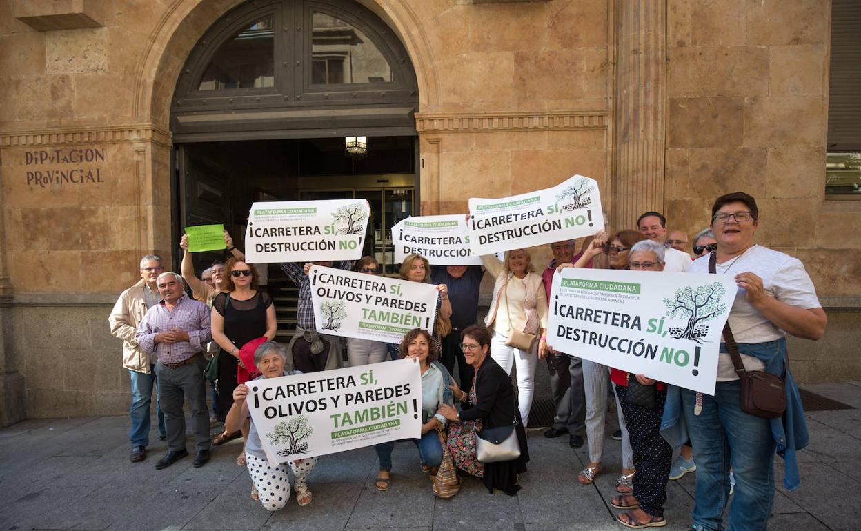 Miembros de la Plataforma Ciudadana y de Acasa, a la puerta de la Diputación, mostrando varias pancartas. 