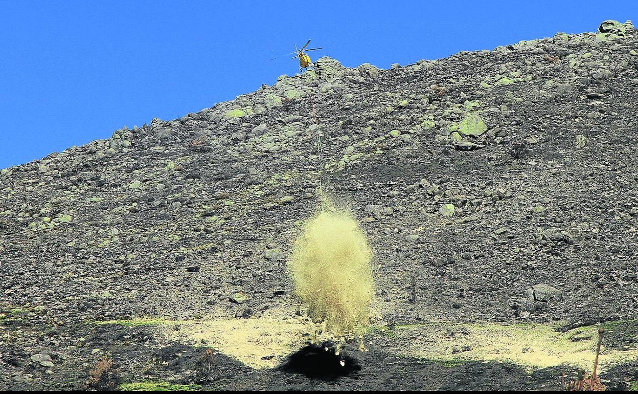 Un helicóptero vierte sobre el suelo quemado la paja de cereal que acolcha el terreno y lo protege de la erosión en el valle del arroyo Morete. 