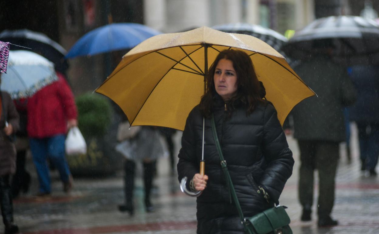 Una mujer bajo la lluvia en Valladolid. 