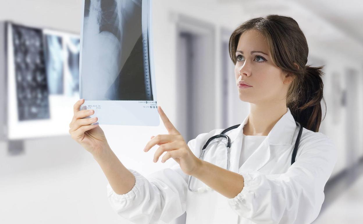 Una doctora examina una radiografía en un hospital.