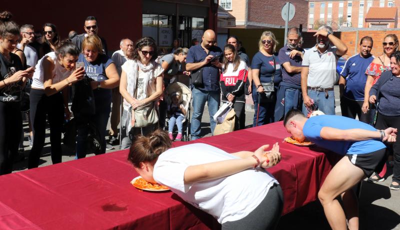 Participantes en el concurso de comer sin manos en el barrio de Pilarica de Valladolid.