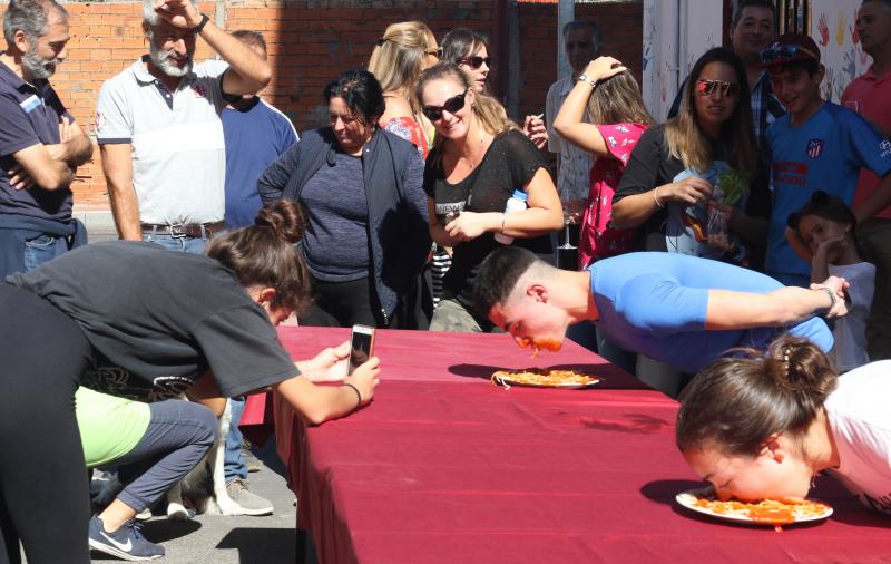 Participantes en el concurso de comer sin manos en el barrio de Pilarica de Valladolid.