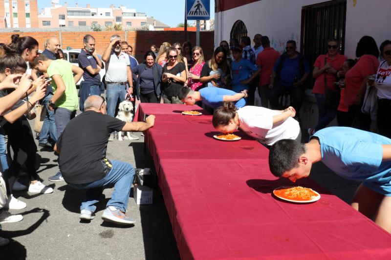 Participantes en el concurso de comer sin manos en el barrio de Pilarica de Valladolid.