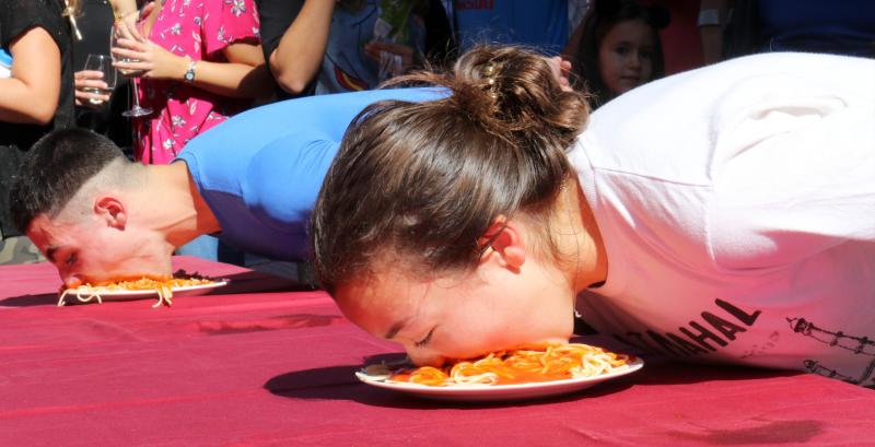 Participantes en el concurso de comer sin manos en el barrio de Pilarica de Valladolid.