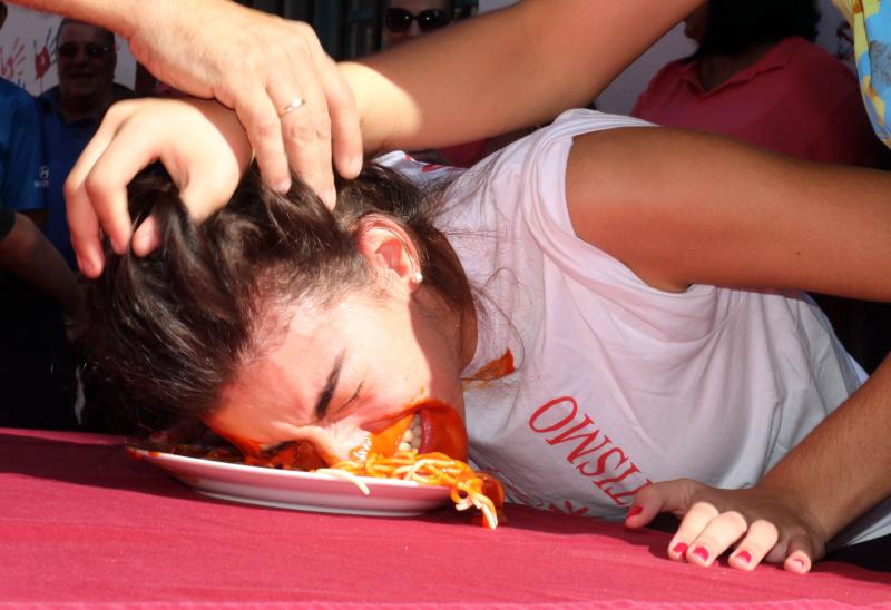 Participantes en el concurso de comer sin manos en el barrio de Pilarica de Valladolid.