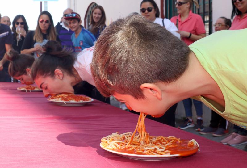 Participantes en el concurso de comer sin manos en el barrio de Pilarica de Valladolid.