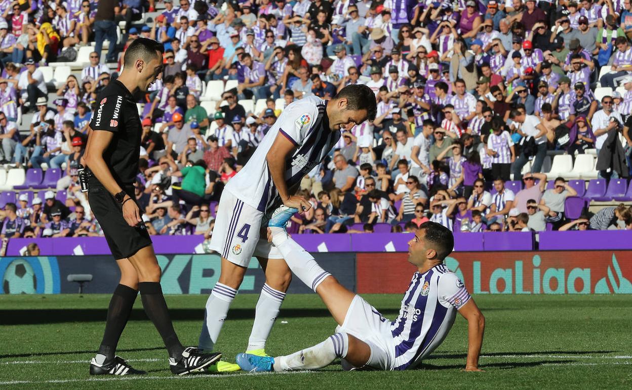 Kiko Olivas estira la pierna derecha de Moyano durante el partido frente al Atlético de Madrid.