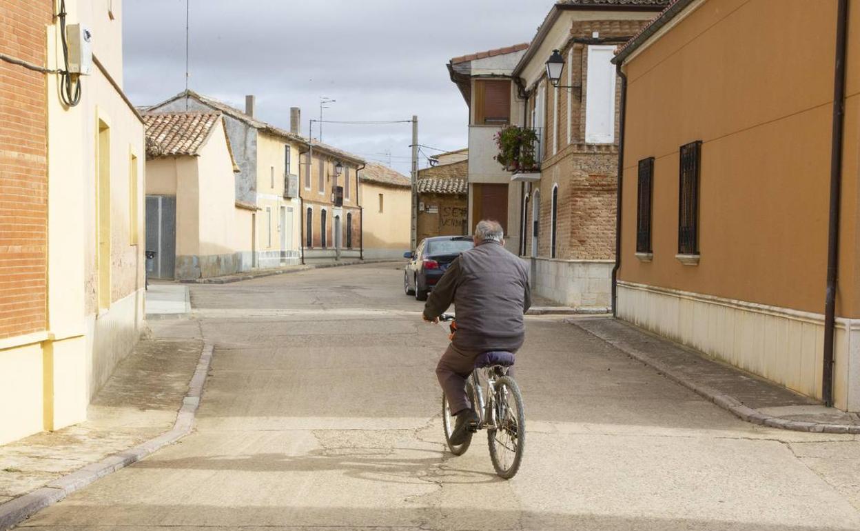 Un vecino en bicicleta circula por una calle de Herrín de Campos.