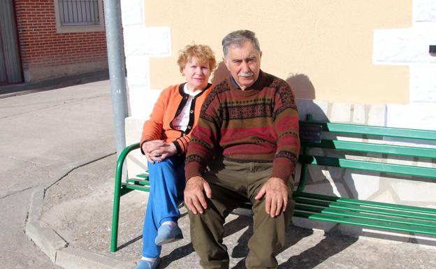 Imagen principal - Arriba, Justina Bayón y Gerardo Herrero, sentados en un banco del pueblo. Abajo, el artista Juan Velasco y su pareja; a la derecha, la escultura 'Serenidad', a al entrada de Perosillo. 