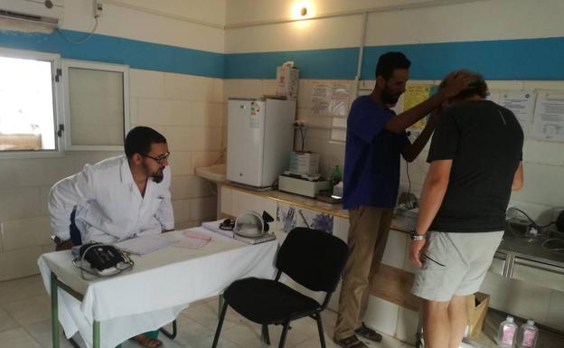 Imagen principal - Arriba, el doctor Mohamed Lamin Bachir, en la sala de urgencias. Debajo, consulta de ginecología y medicamentos en la farmacia del hospital de Auserd. 