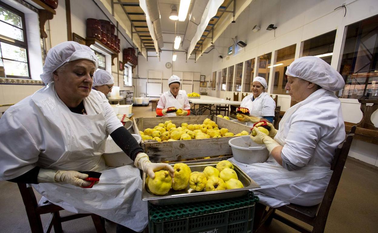 Un grupo de mujeres limpia membrillos en el taller de elaboración de conservas del Palacio de Canedo.