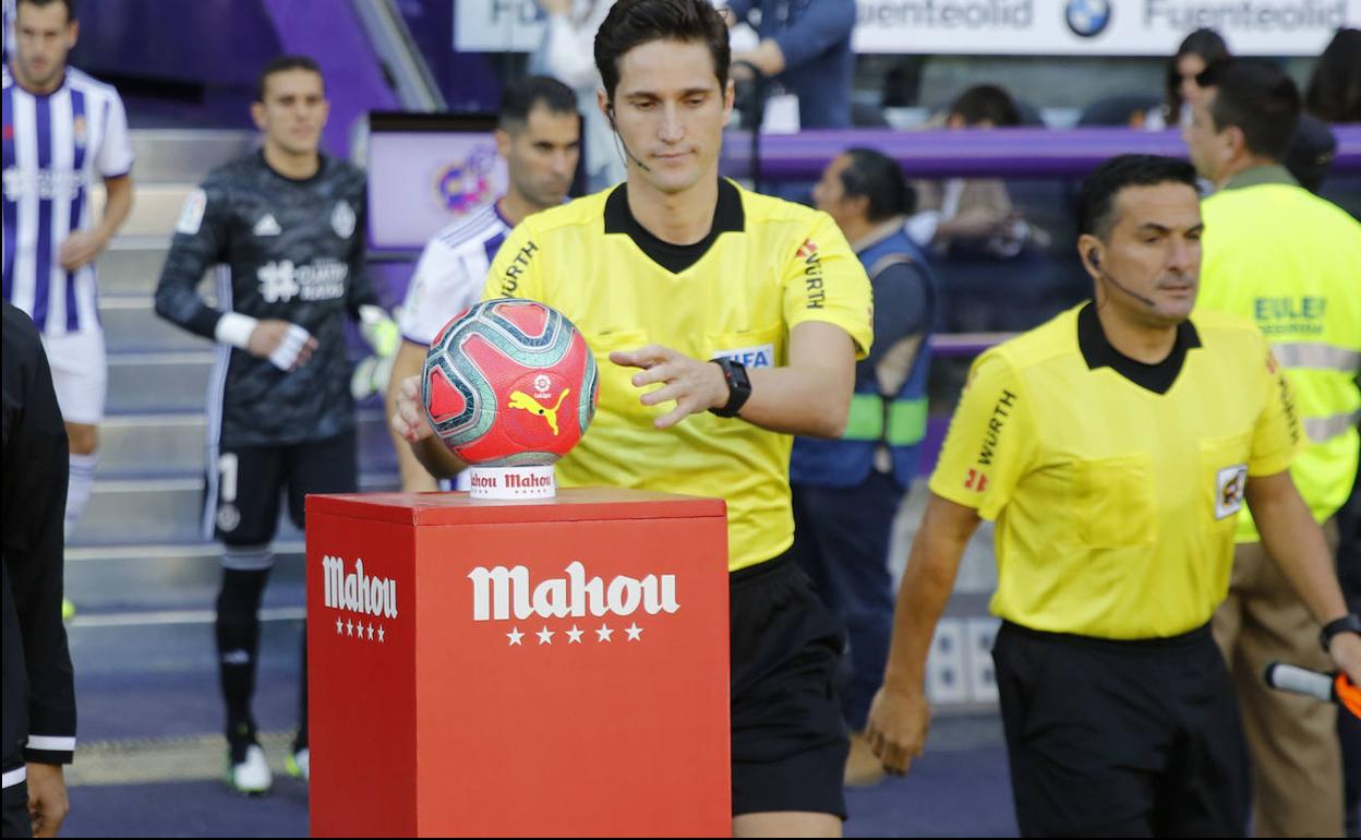 Munuera Montero recoge el balón co nel que se juega el partido antes del comienzo. 