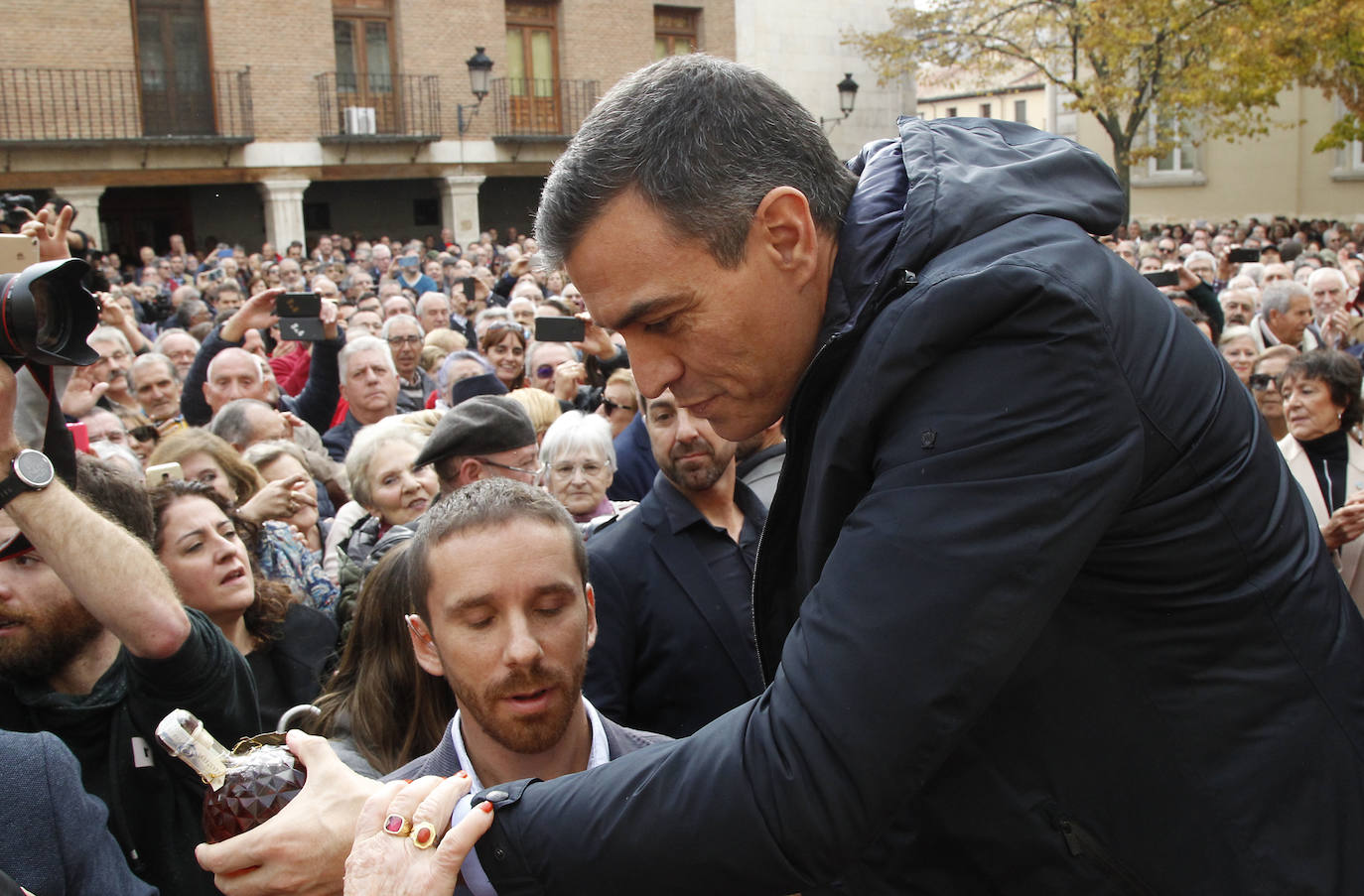 Pedro Sánchez recibe una botella como obsequio de una simpatizante, en la plaza San Francisco.
