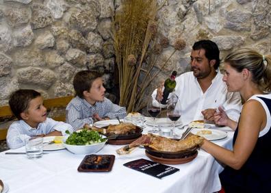 Imagen secundaria 1 - Arriba, lechazo asado de Aranda. Abajo, una familia disfruta del asado y a la derecha, una tapa vanguardista. 