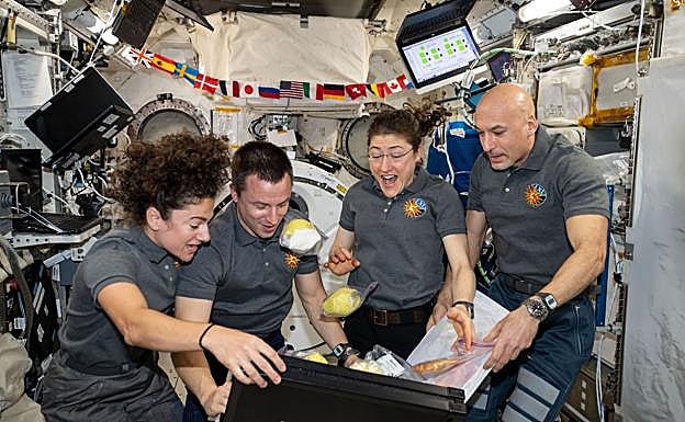 Los astronautas Jessica Meir, Andrew Morgan, Christina Koch y Luca Parmitano desempaquetan un envío de fruta en la Estación Espacial Internacional.