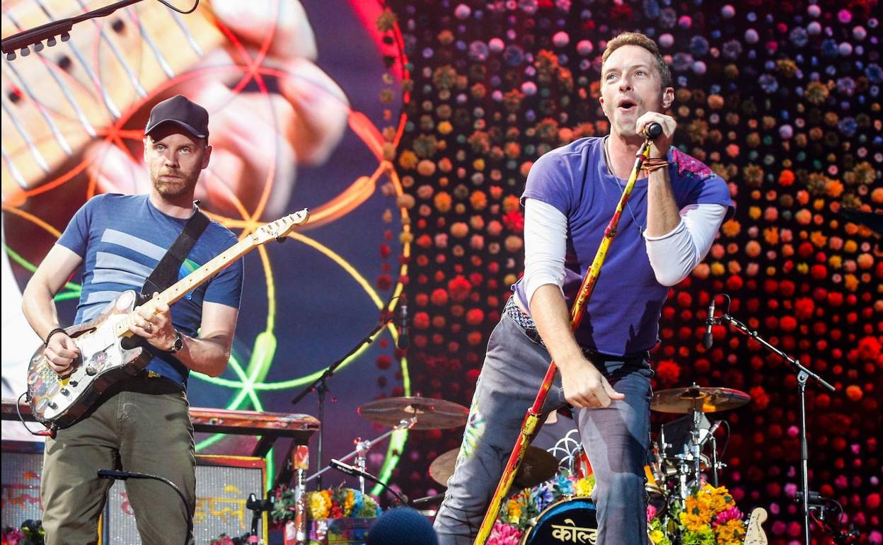 El cantante principal de la banda británica Coldplay Chris Martin (D) con el guitarrista Jonny Buckland durante un concierto en París en 2017.