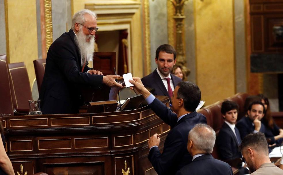 Agustín Zamarrón recoge la papeleta del presidente en funciones, Pedro Sánchez, en la sesión del 21 de mayo.