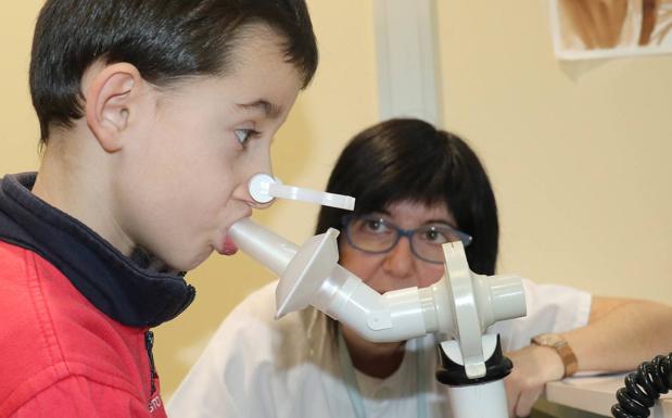 Una enfermera enseña a un niño a hacer una espirometría en la Unidad de Asma del Río Hortega.. 