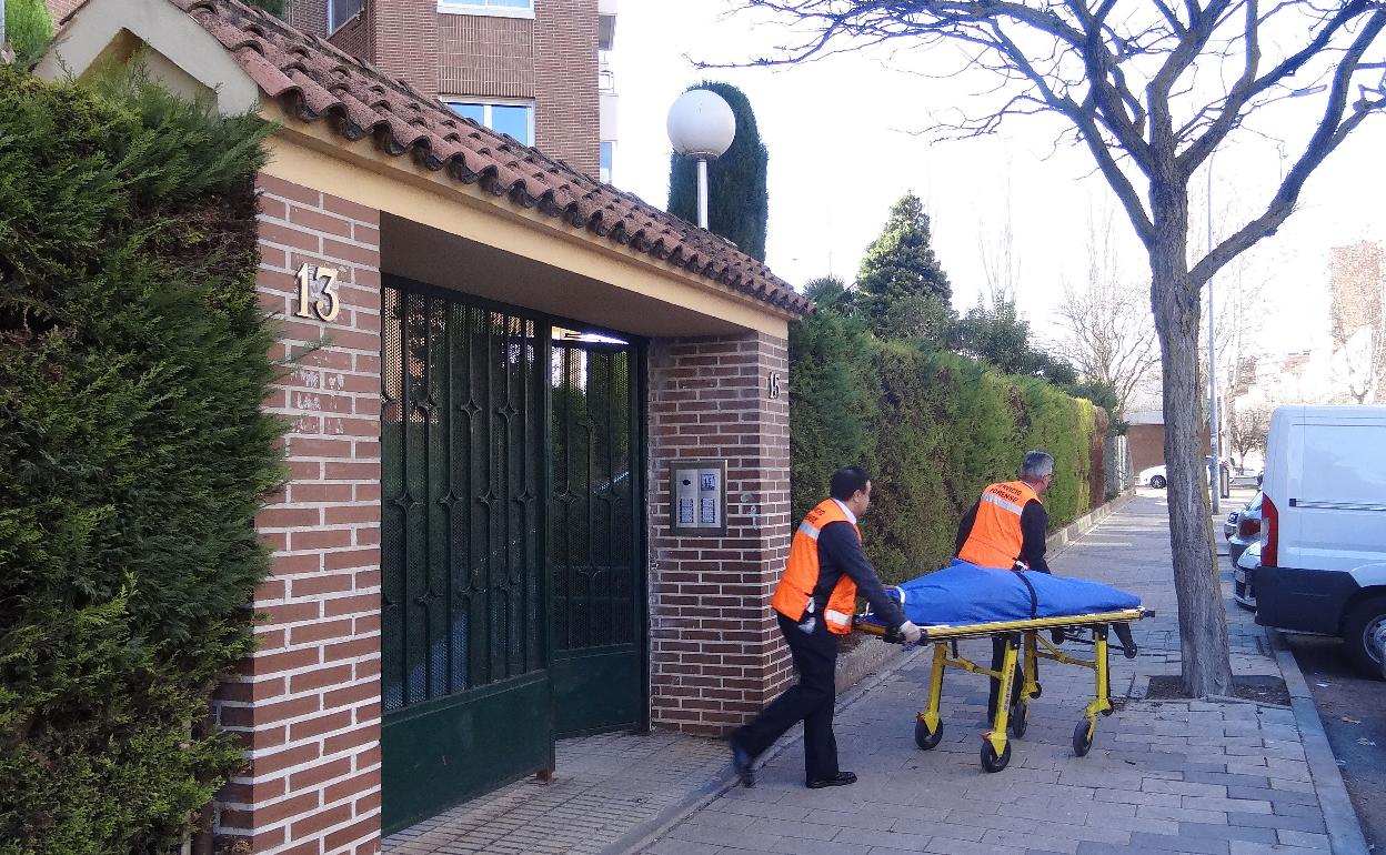 Servicios funerarios trasladan el cadáver del domicilio de Parquesol donde ocurrió el crimen. 