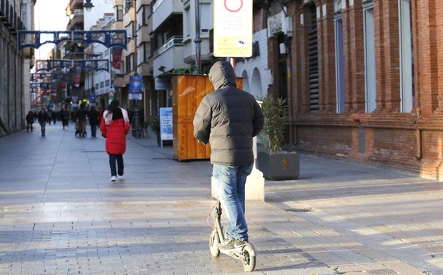 Un patinete eléctrico por la Calle Mayor.