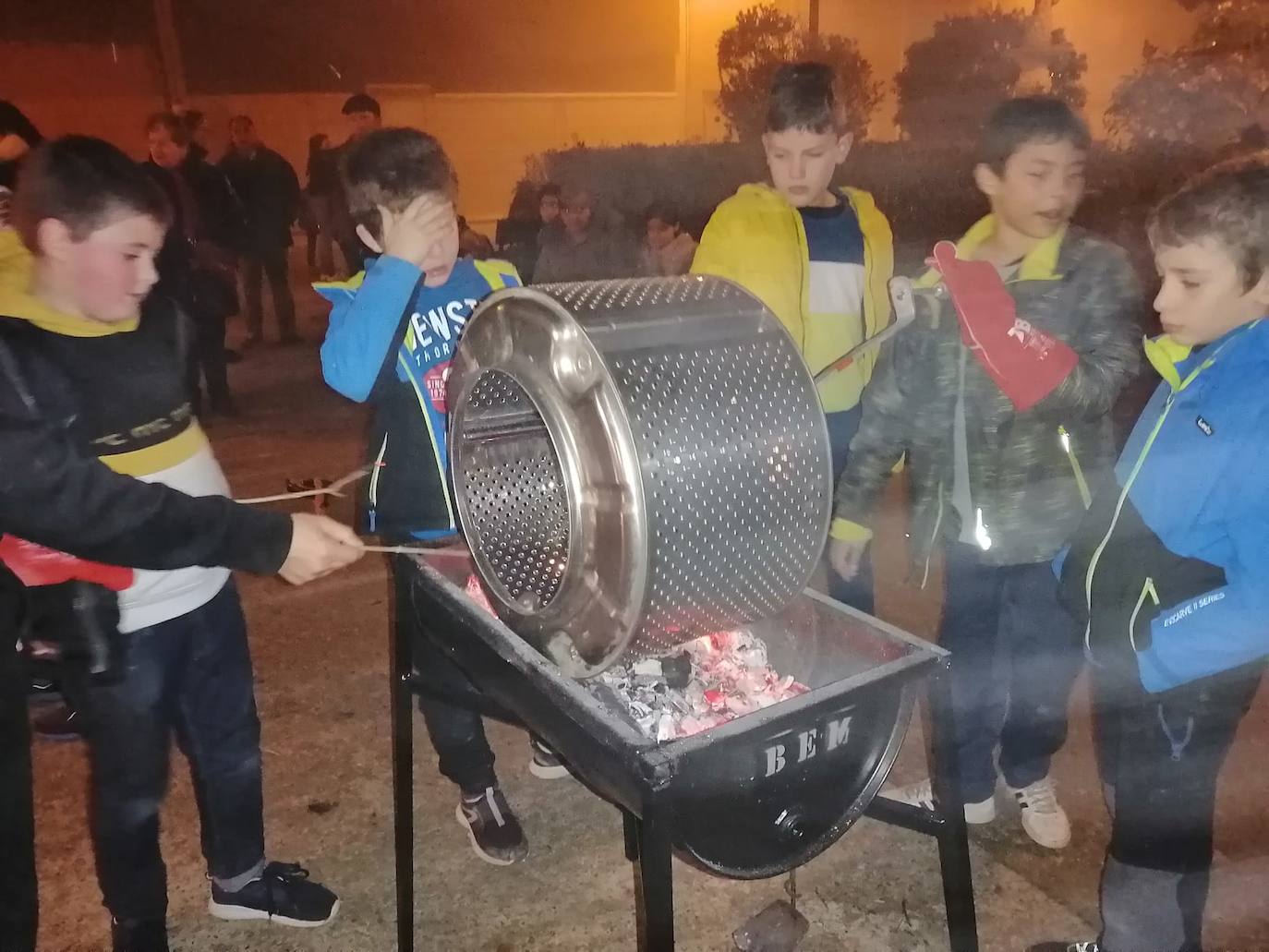 Los niños asando las castañas en el día festivo. 