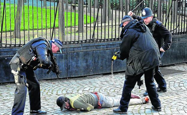 Un subfusil, una táser y una porra extensible apuntan a un detenido en Londres.