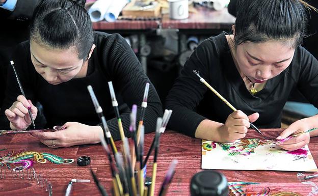 Dos mujeres trabajan en un muñeco.