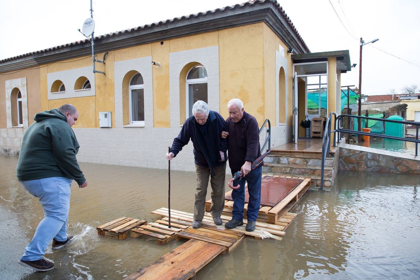 Dos vecinos tienen que ser sacados del bar por la crecida del río Orbigo en Vecilla de la Polvorosa.
