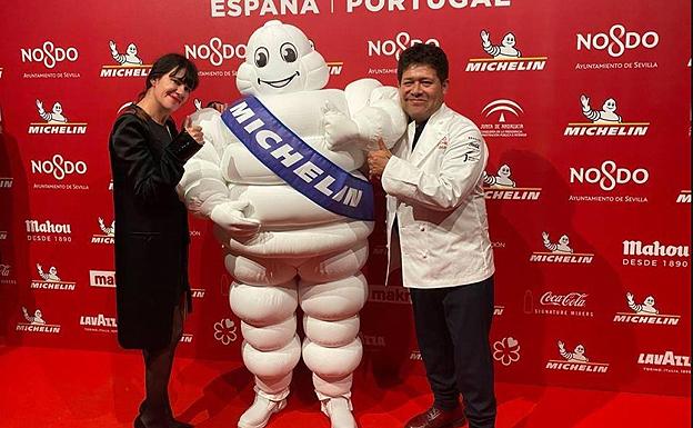 Amaya Arzuaga y Víctor Gutiérrez posan con un Bibendum de Michelin. 